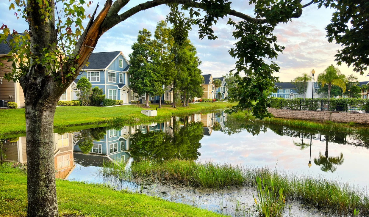 Houses by a pond with tree reflections.