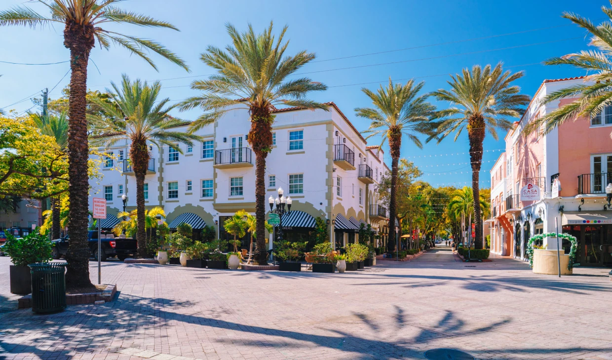 Street with palm trees and Mediterranean architecture.