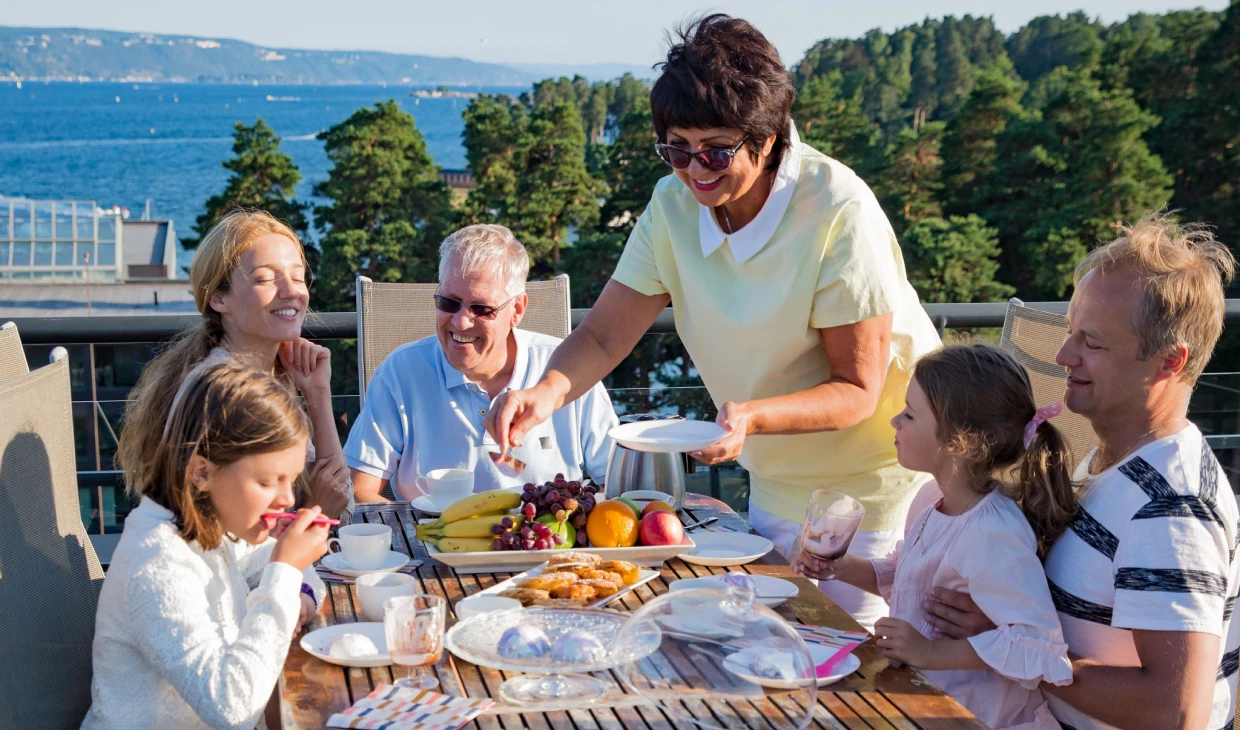 Family enjoying outdoor meal by the sea.