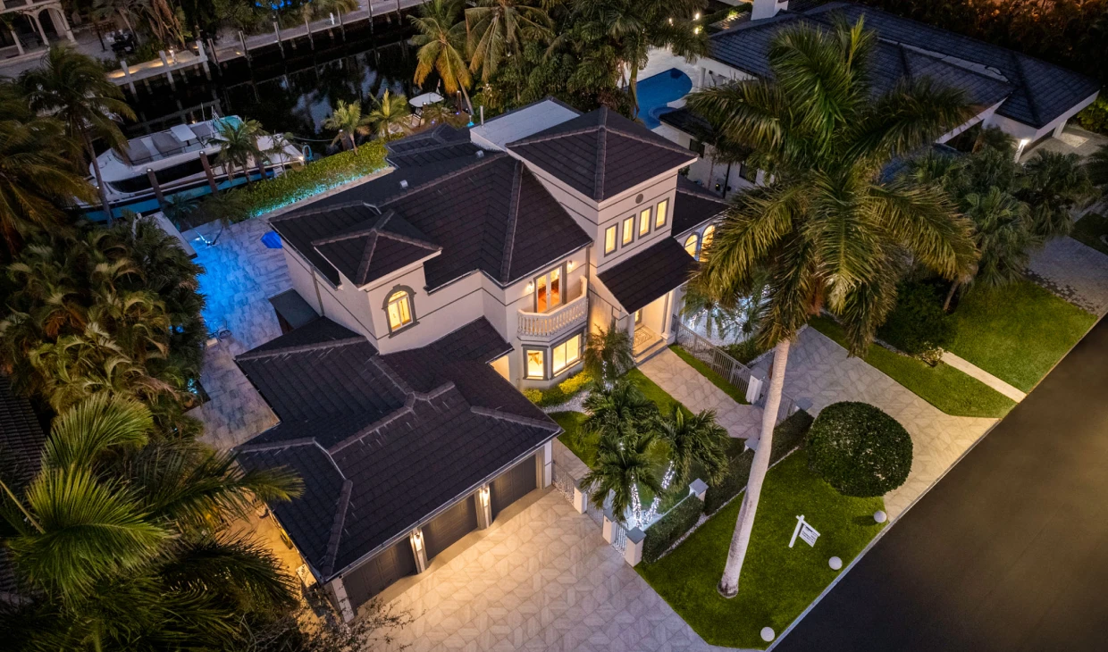 Luxury house with palm trees at night.